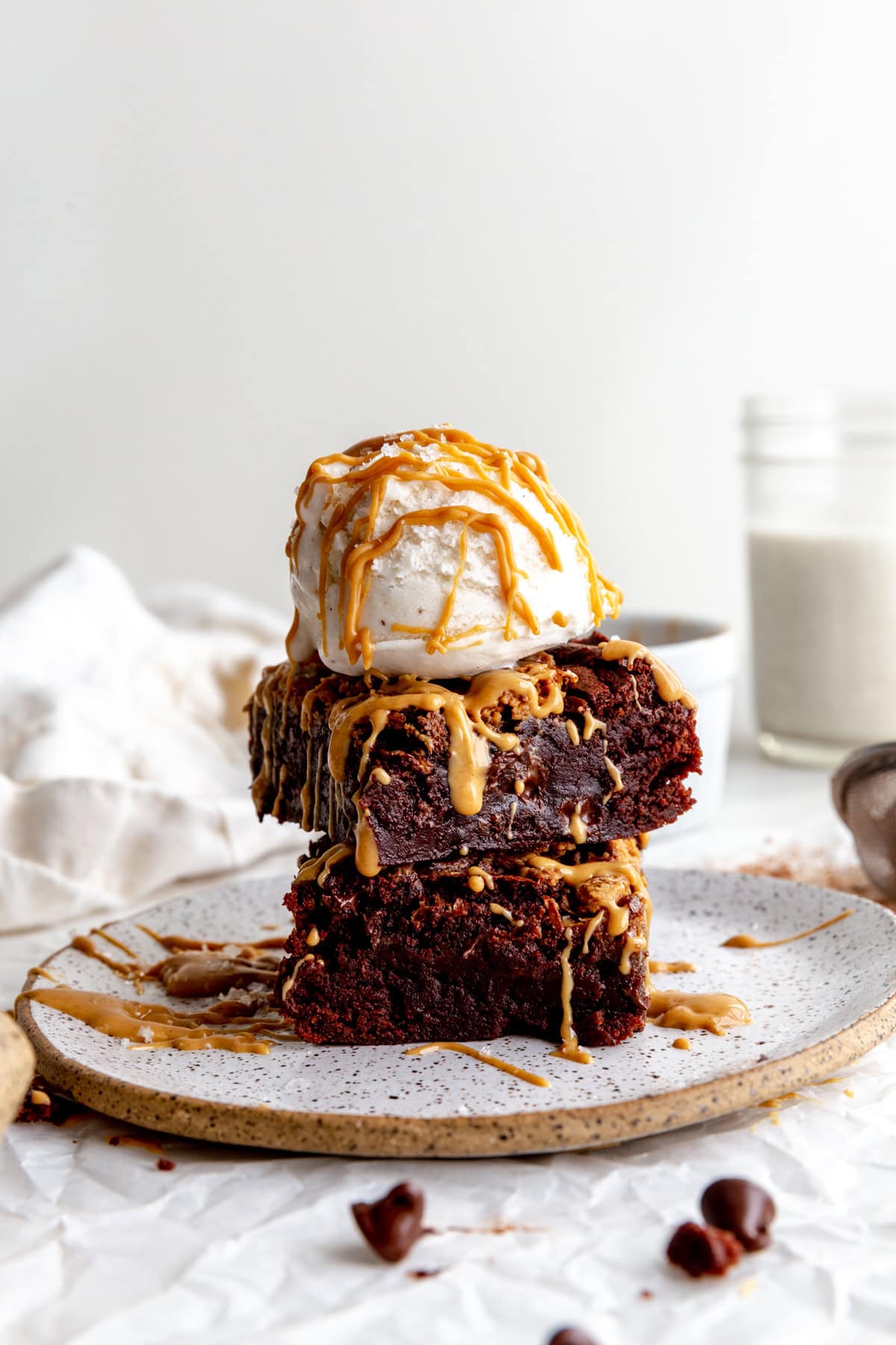Stack of peanut butter brownies topped with a scoop of vanilla ice cream.
