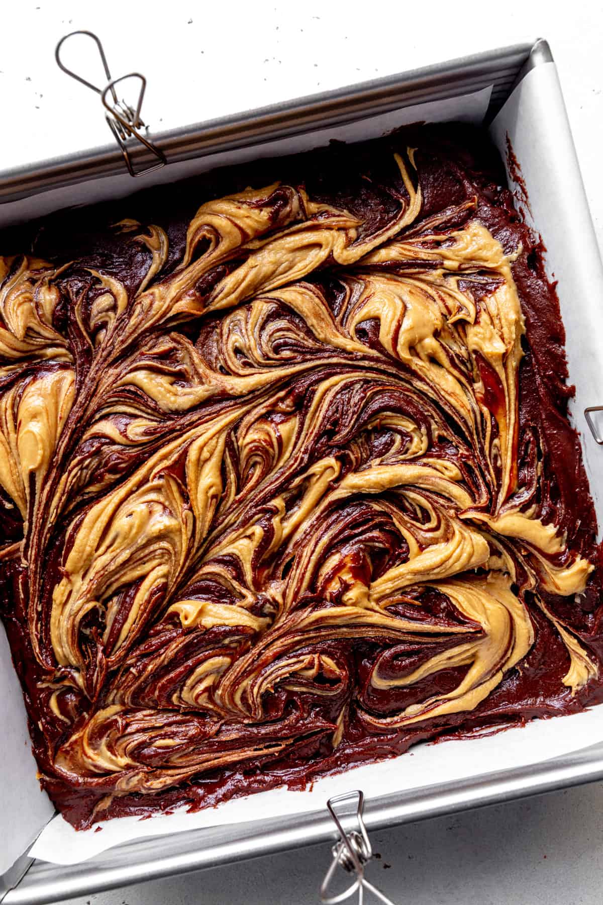 Unbaked peanut butter brownies in a square pan.