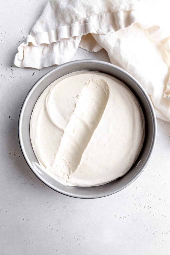 Vanilla ice cream in a round cake pan and a white linen napkin.