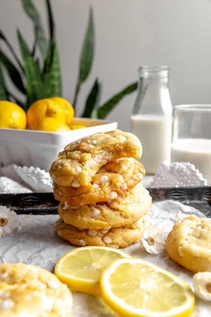 Stack of lemon white chocolate cookies and a jug of milk.