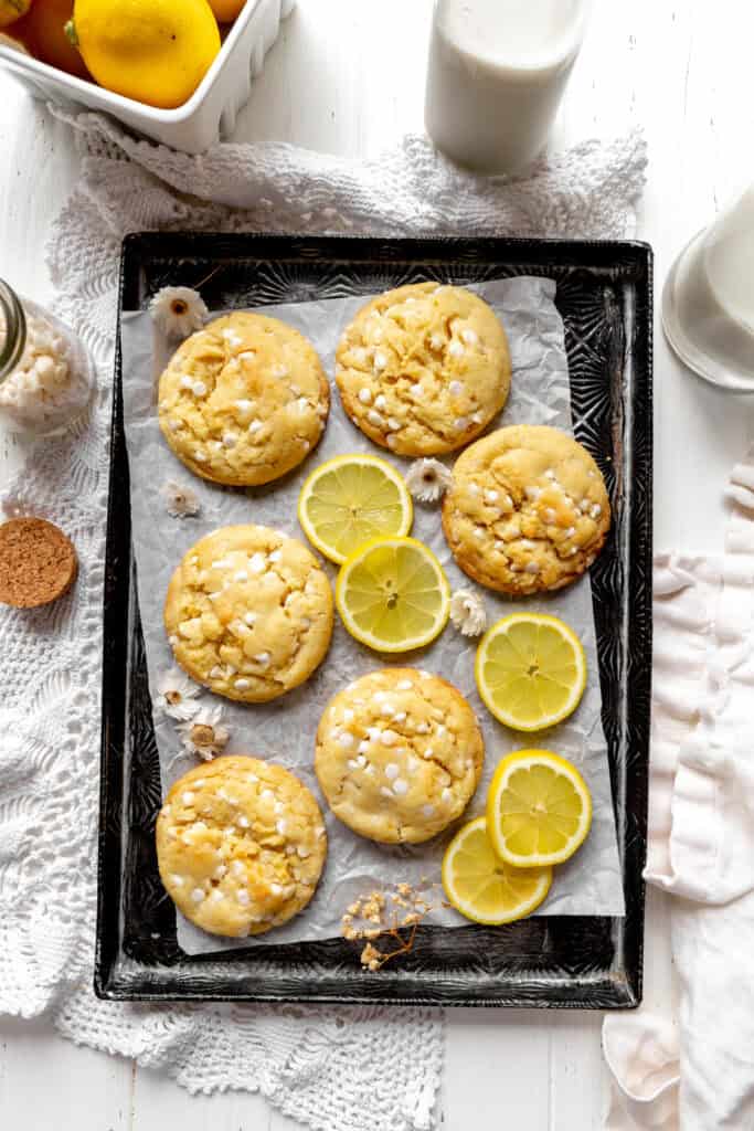 Lemon white chocolate cookies, lemons and a jug of milk.