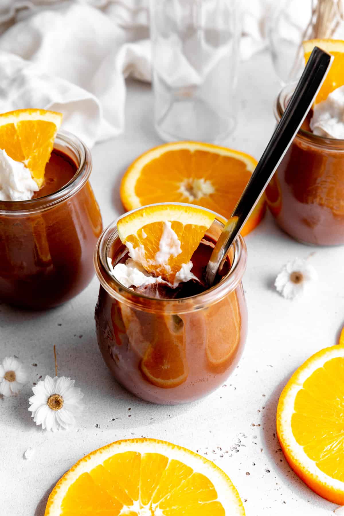 Spoon digging into a jar of orange chocolate mousse.