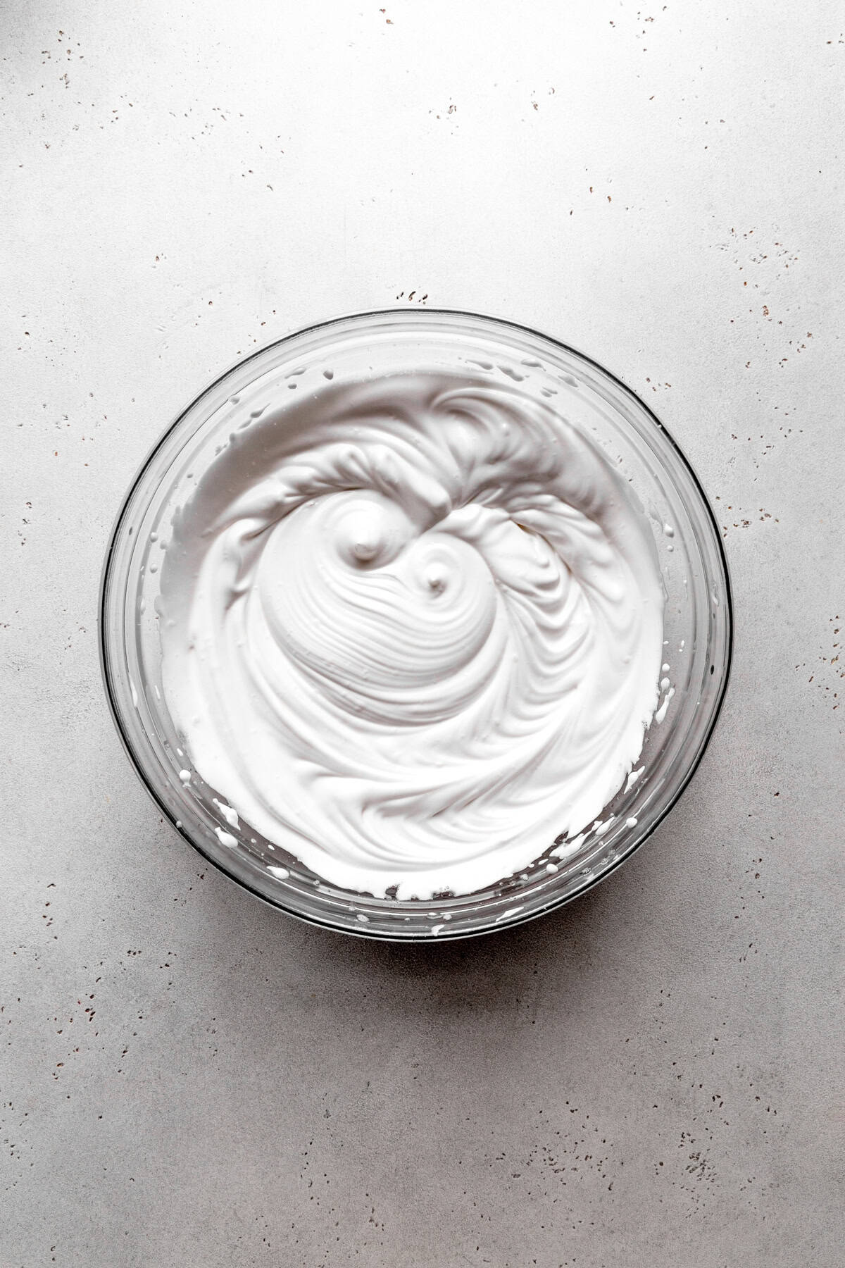 Glass bowl of whipped aquafaba meringue.
