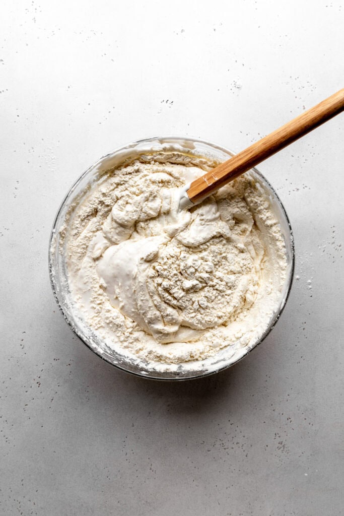 Glass bowl of aquafaba meringue mixed with flower.