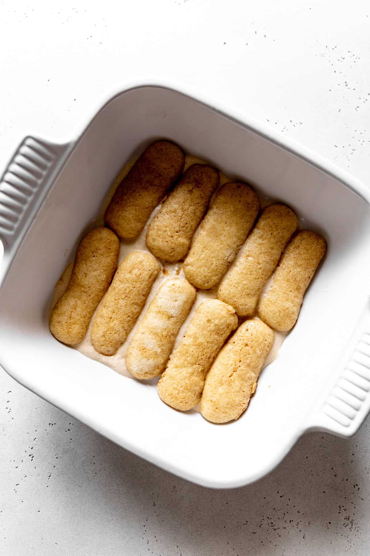 Ladyfingers laid out in a square dish.