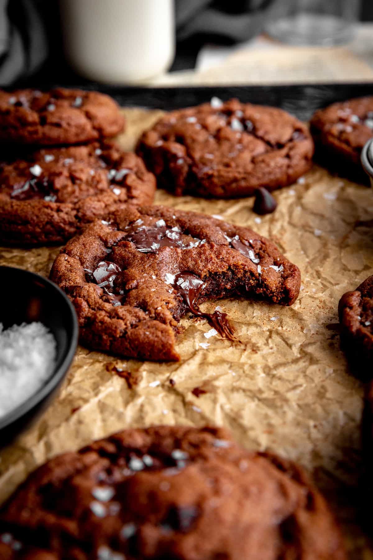 A double chocolate cookie with a bite taken out of it.