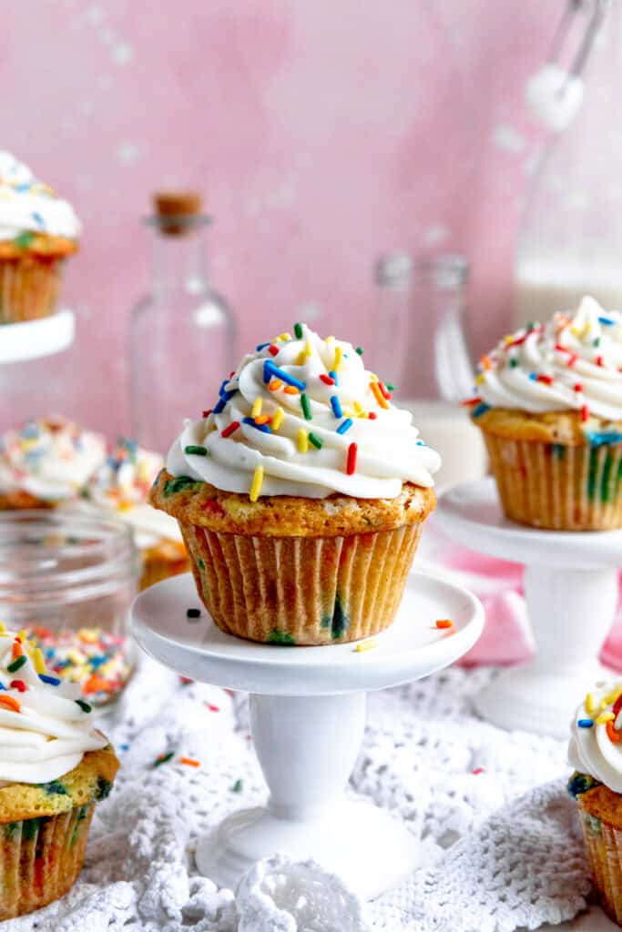Funfetti cupcake on a white pedestal.