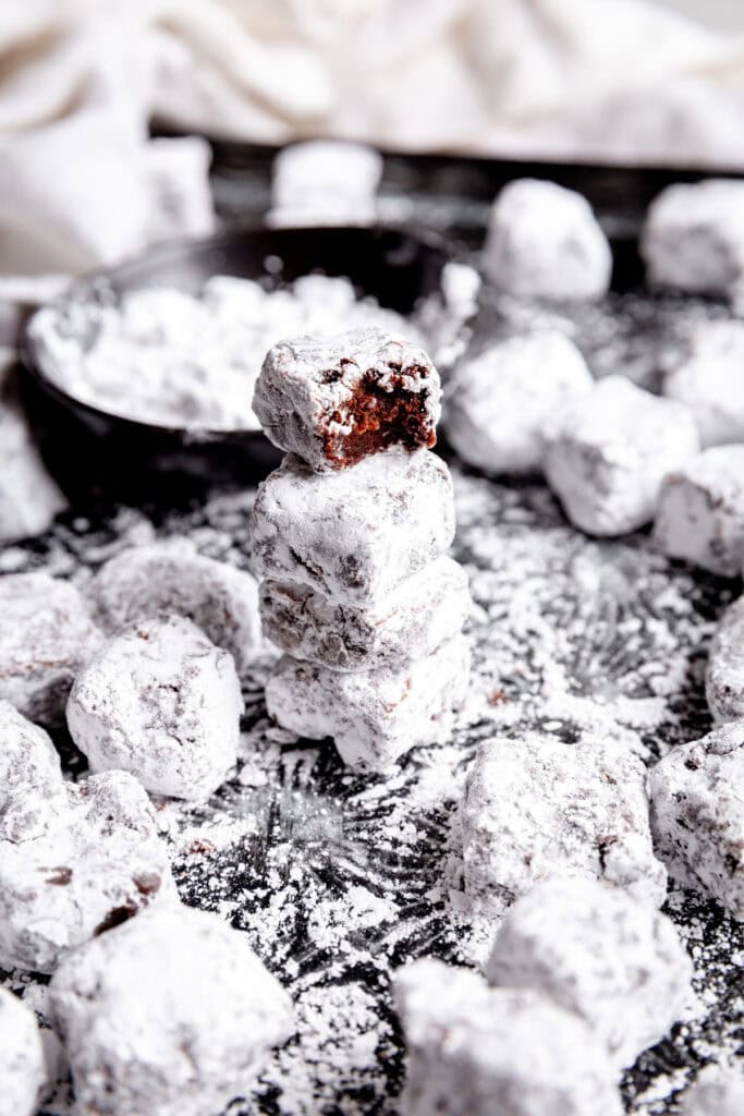 Stack of brownie bites and a white linen napkin.