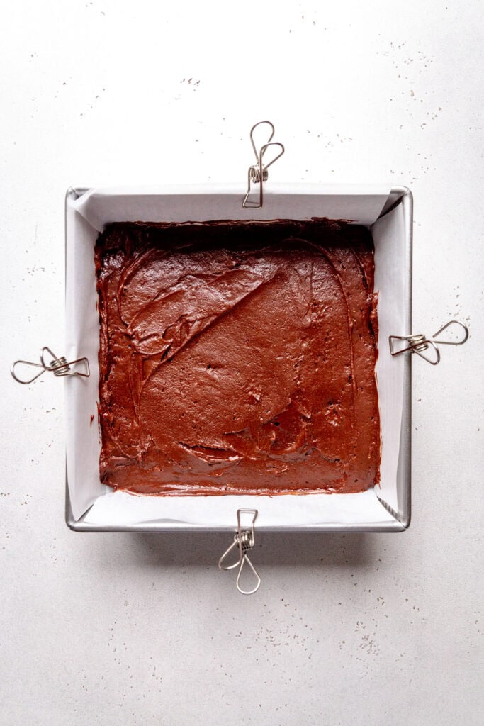Unbaked brownies in a square pan.