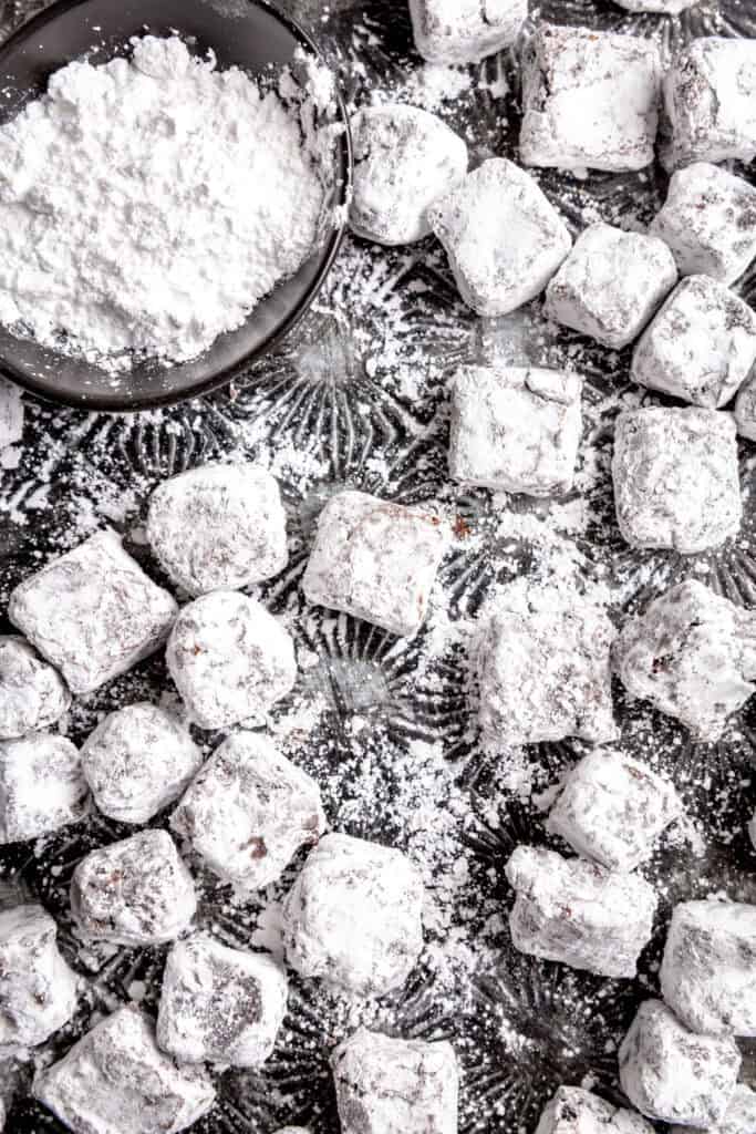 Brownie bites and a cup of powdered sugar.