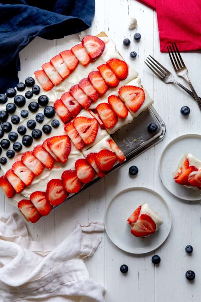 American flag cake and pieces of cake on white plates.