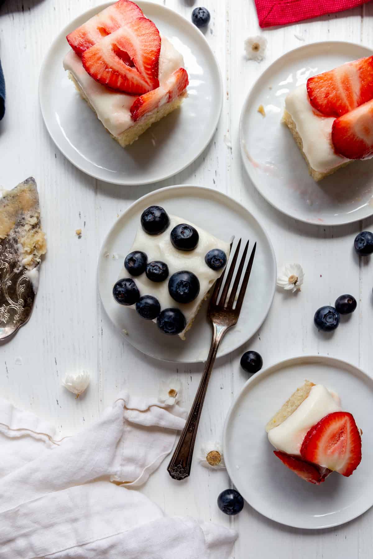 Pieces of flag cake on white plates and a fork.