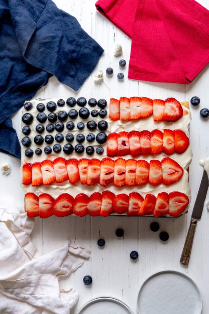 American flag cake, two plates and three red, white and blue linen napkins.