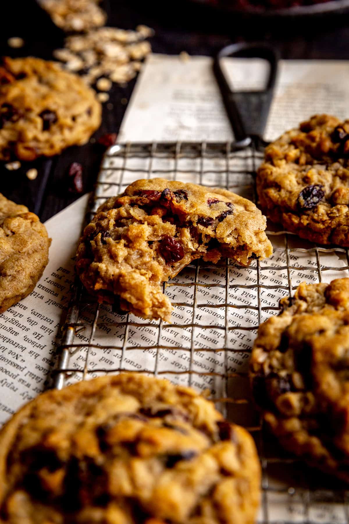 Oatmeal raisin cookie with a bite taken out of it on a wire rack.