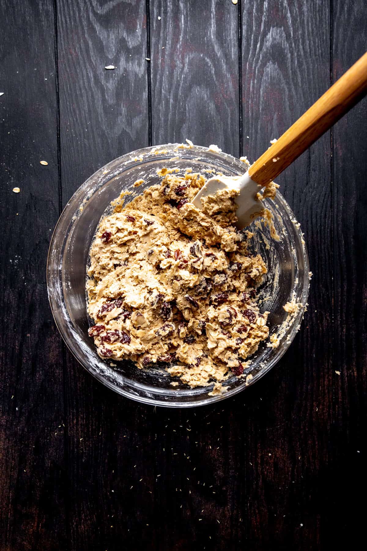 Oatmeal raisin cookie dough in a glass bowl.