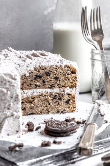 Oreo cake, a jar of forks and a jug of milk.