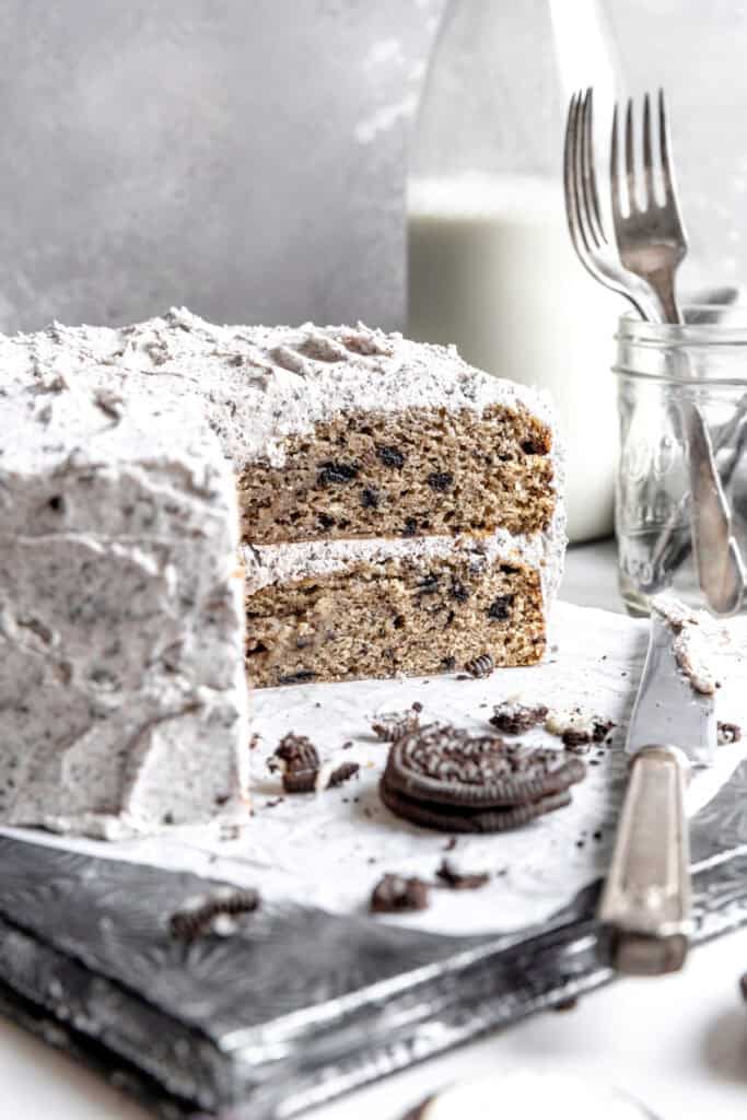 Oreo cake on a baking sheet, a jar of forks and a jug of milk.
