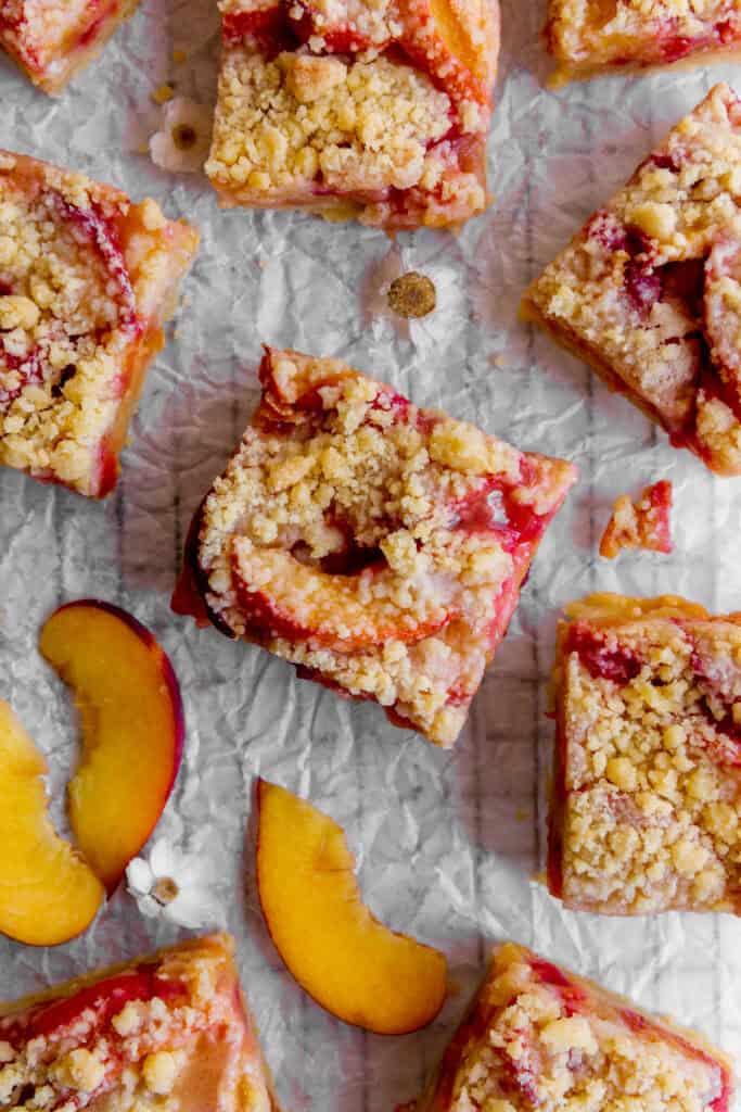 Peach crumble bars, white daisies and fresh peach slices.