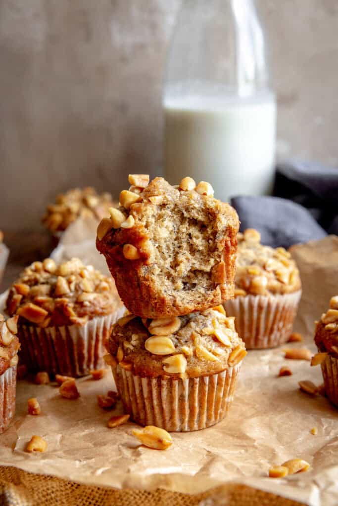 Peanut butter banana muffin with a bite taken out of it stacked on another muffin.