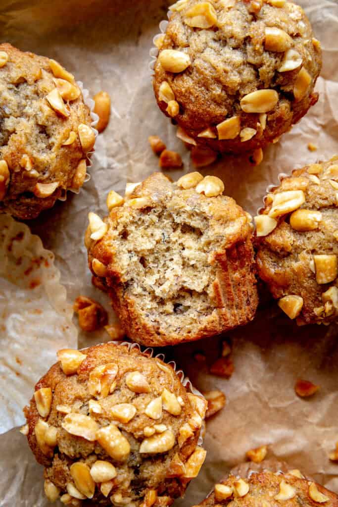 Peanut butter banana muffin with a bite taken out of it, laying on a baking sheet.