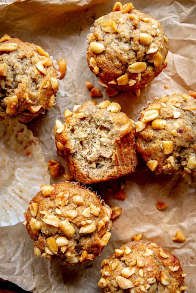 Peanut butter banana muffin with a bite taken out of it, laying on a baking sheet.