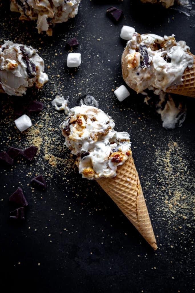 Sugar cone topped with two scoops of s'mores ice cream.