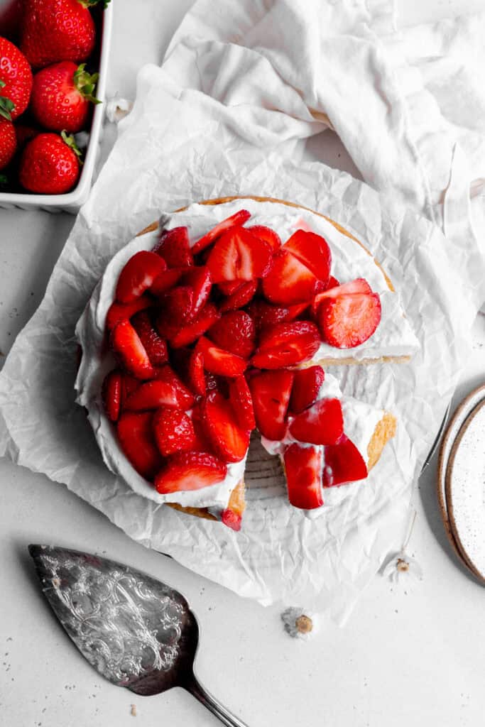 Strawberry shortcake cake, a basket of strawberries and a linen napkin.