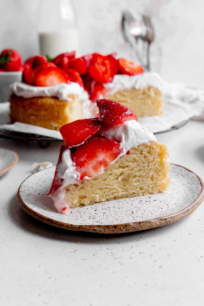 Slice of strawberry shortcake cake on a white plate.
