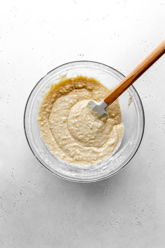 Shortcake batter in a glass bowl with a rubber spatula.