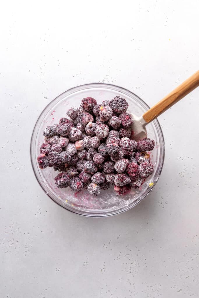 Blackberries tossed in flour and sugar with a rubber spatula.