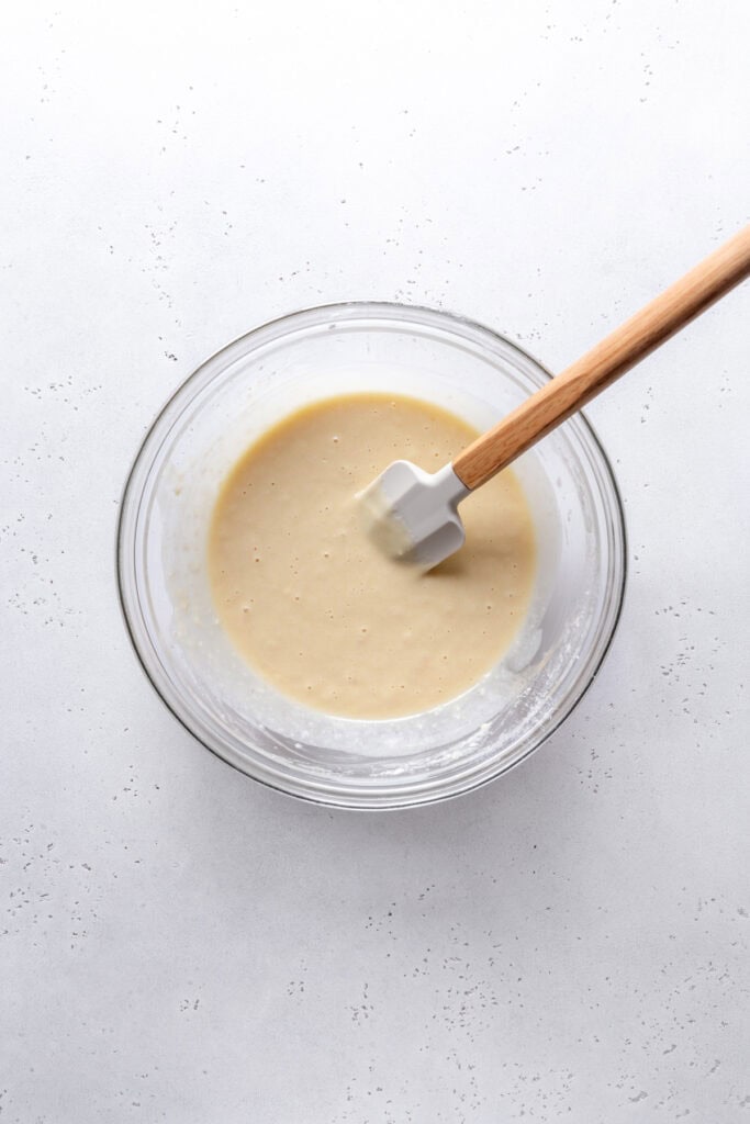 Cobbler topping in a glass bowl with a rubber spatula.