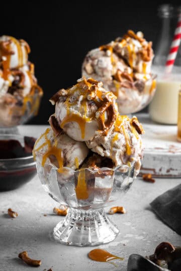 Scoops of caramel pretzel ice cream in a glass dish.