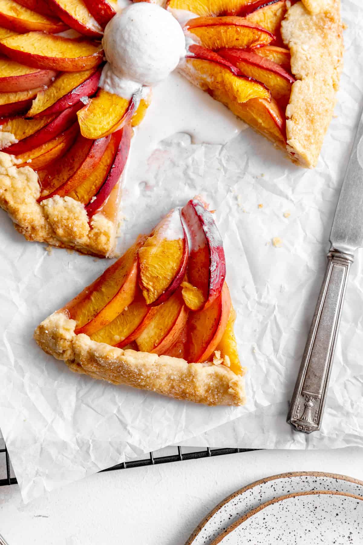 Slice of nectarine galette on white parchment paper.