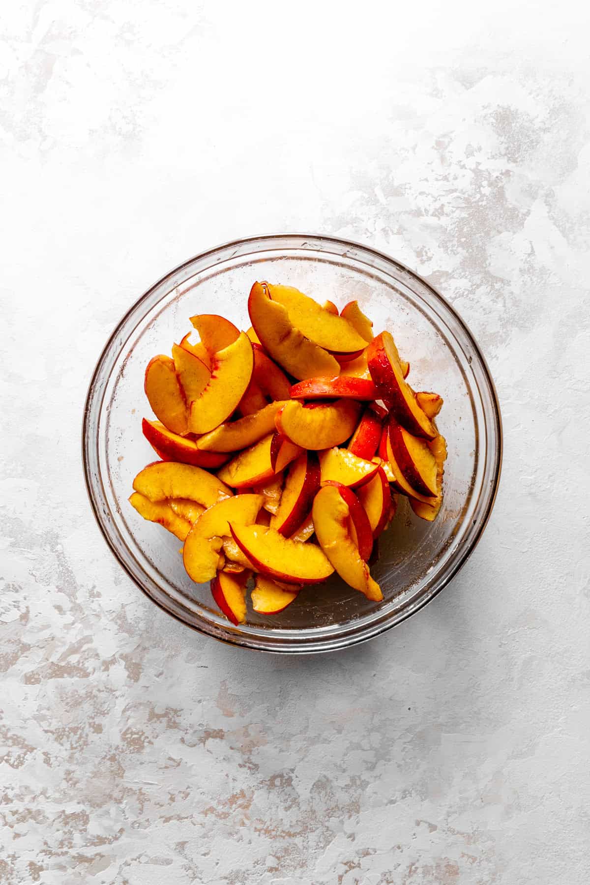 Sliced nectarines in a glass bowl.
