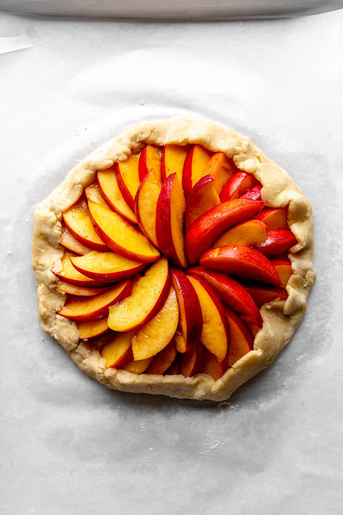 Unbaked nectarine galette on a baking sheet.