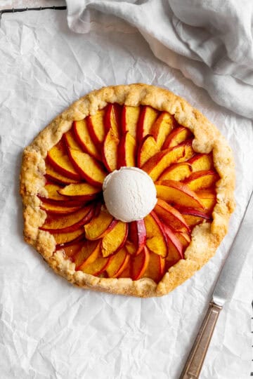 Nectarine galette on a cooling rack with a knife and a linen napkin.