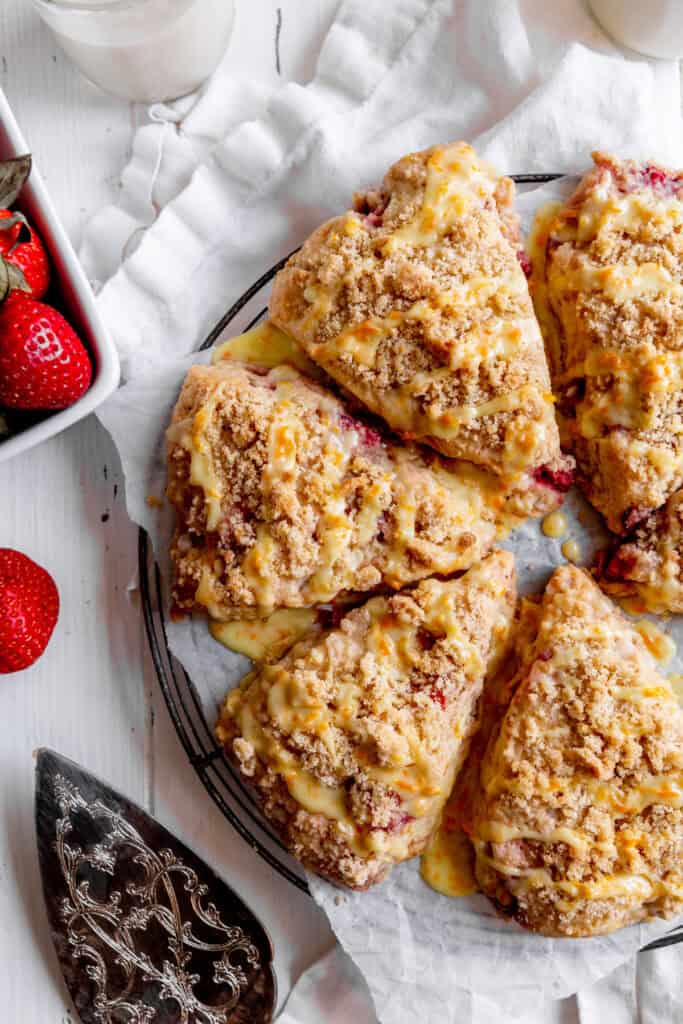Strawberry rhubarb scones, a glass of milk and a basket of strawberries.