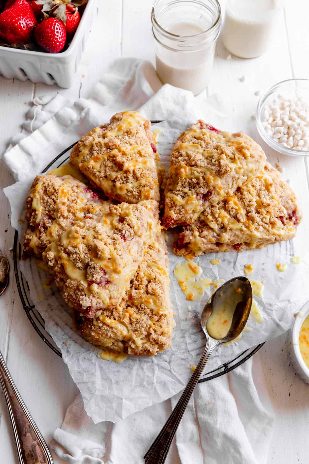 Strawberry rhubarb scones on a wire rack and a basket of strawberries.