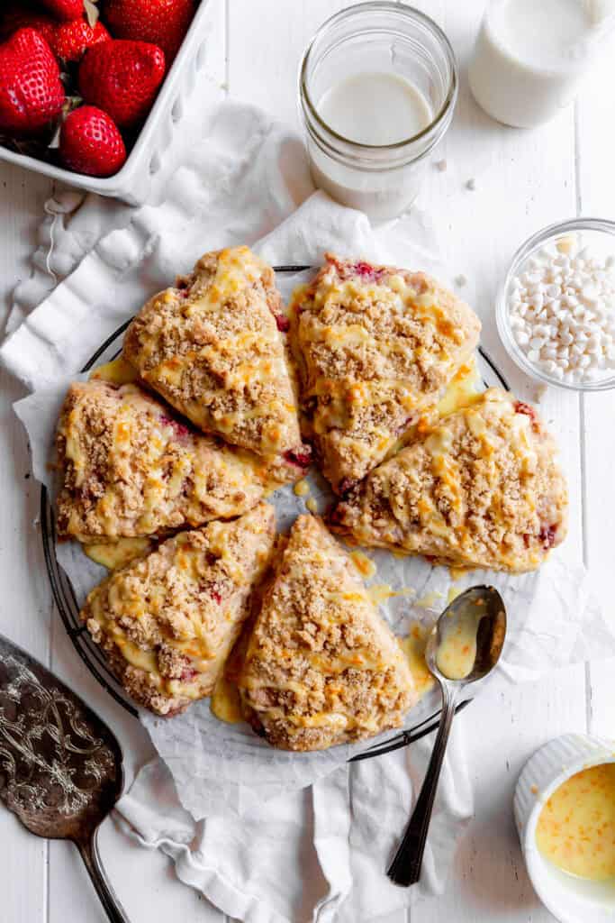 Strawberry rhubarb scones, a bowl of white chocolate chips and a basket of strawberries.