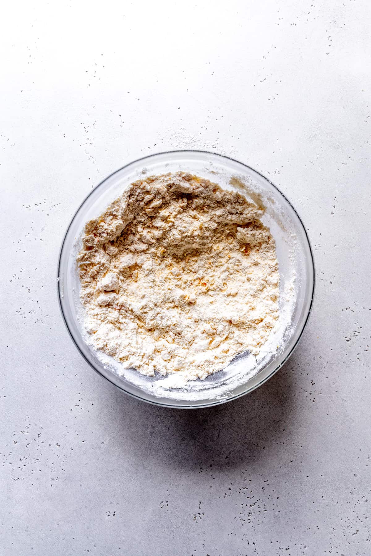 Glass bowl of butter cut into flour.