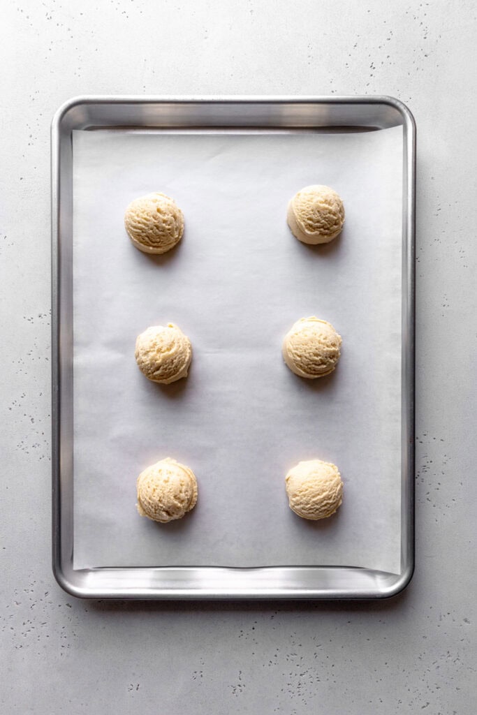 Unbaked sugar cookies on a baking sheet.