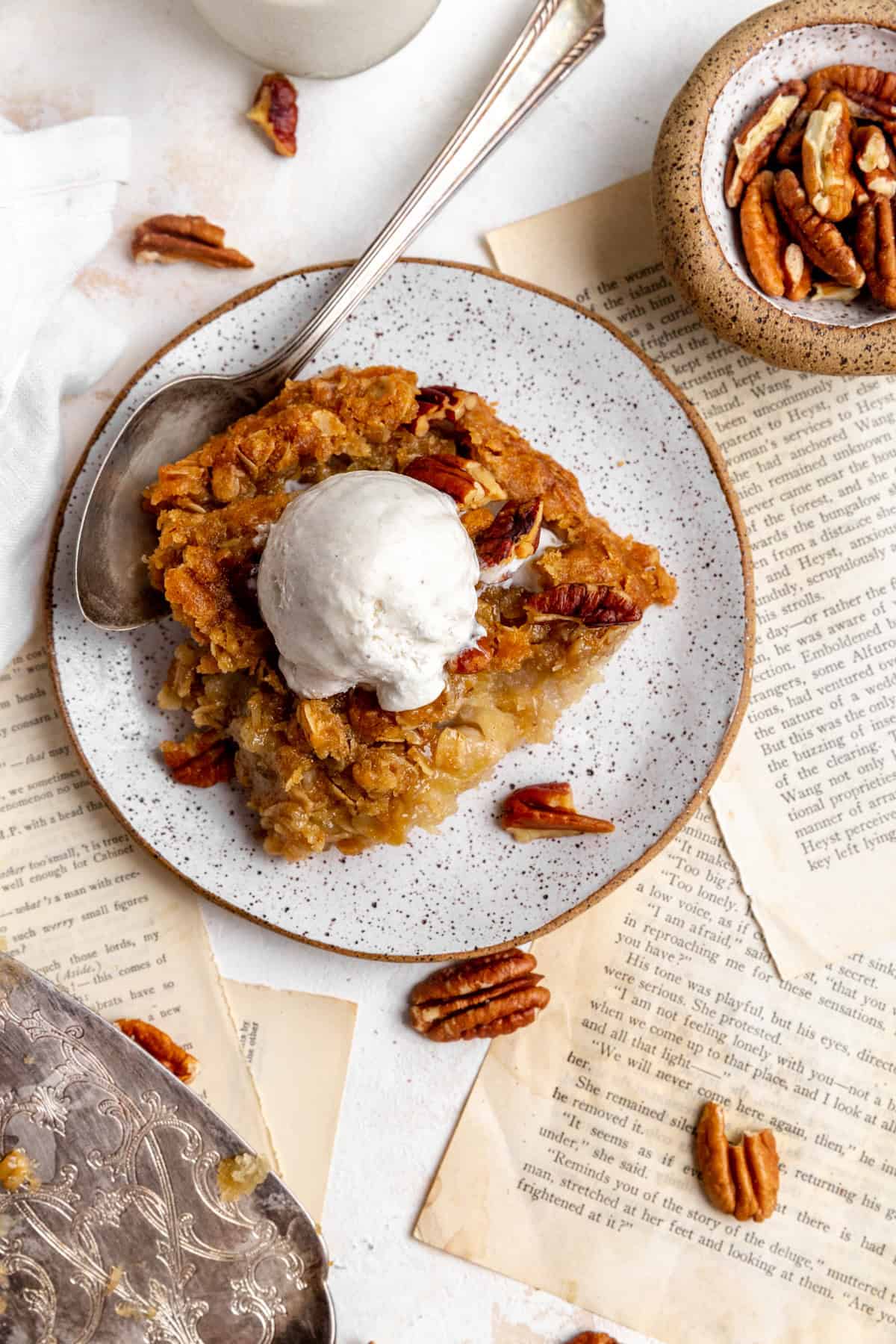 Spoon digging into banana cobbler on a plate.