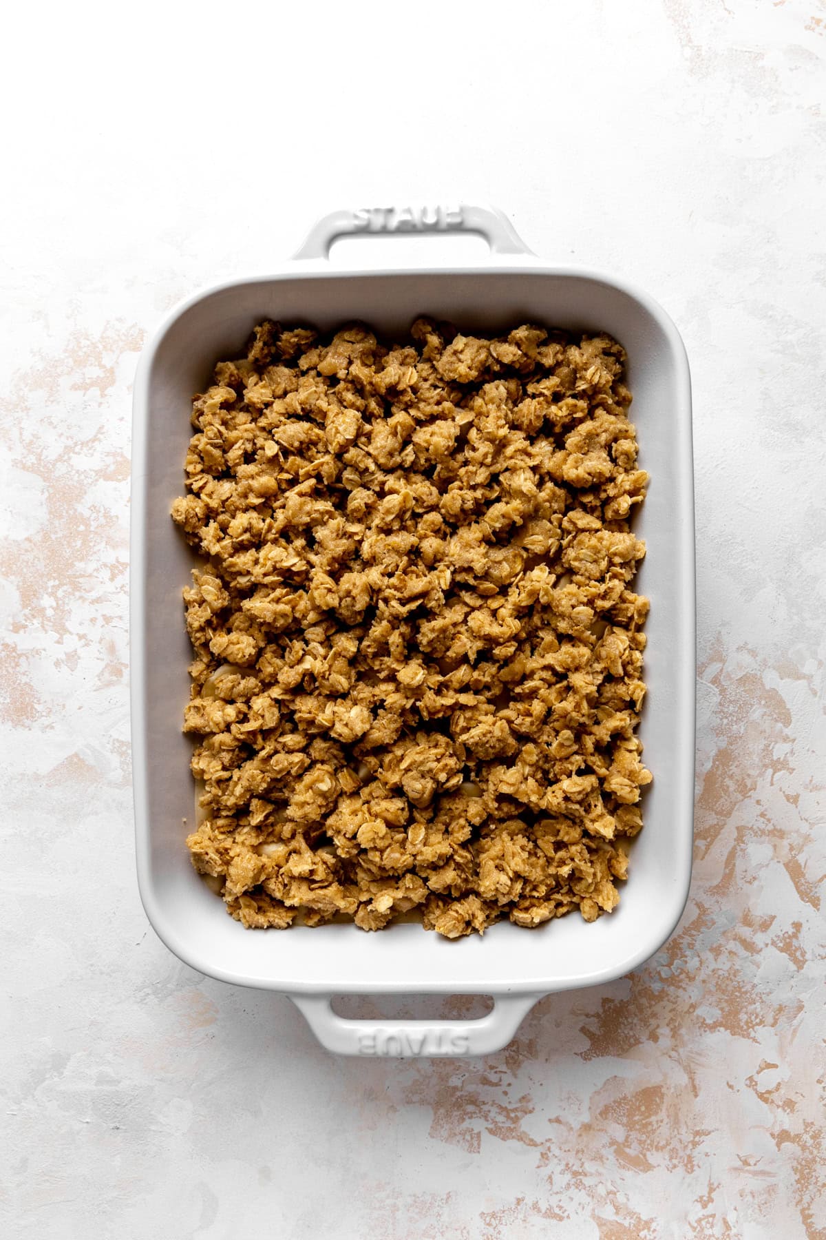 Unbaked banana cobbler in a white baking dish.