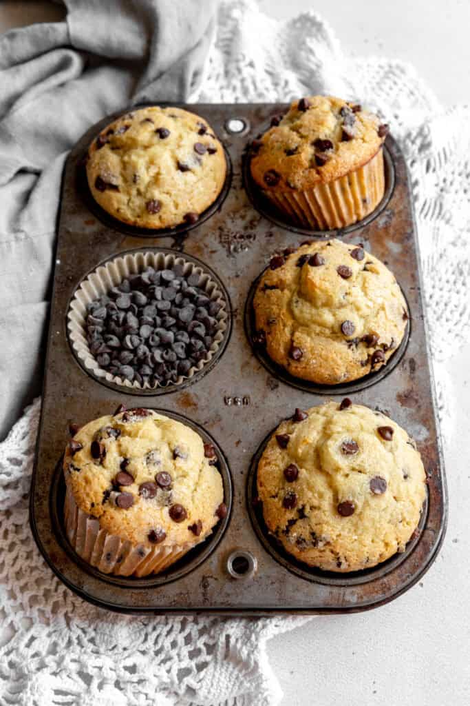 Pan full of chocolate chip muffins and a gray linen napkin.