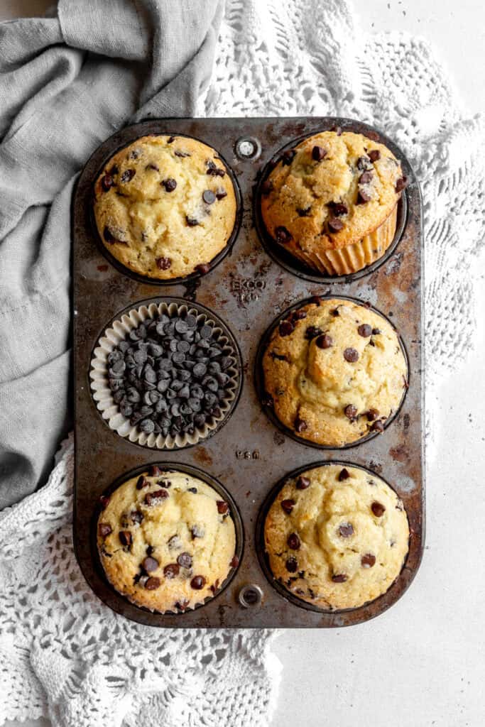 Pan full of chocolate chip muffins and a gray linen napkin.