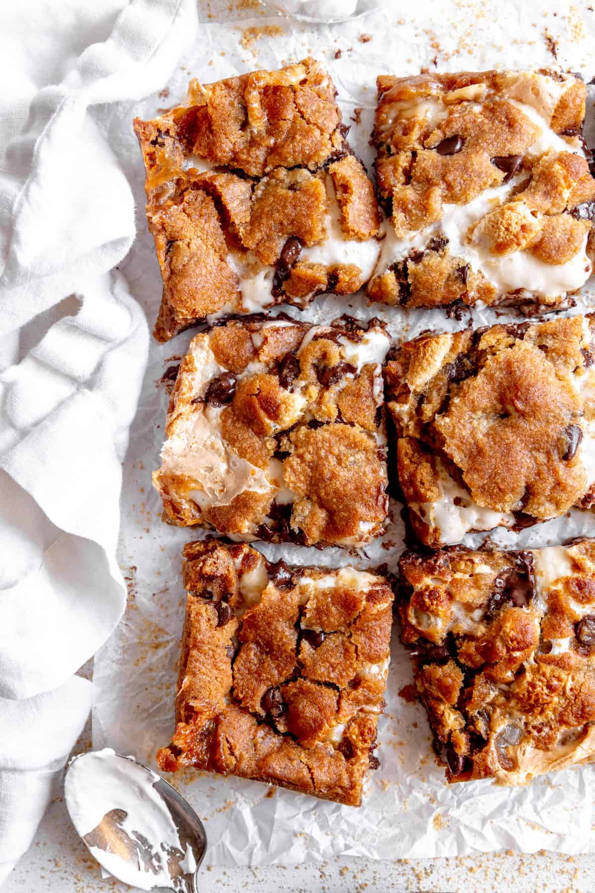 S'mores bars, a linen napkin and a spoon covered in marshmallow fluff.