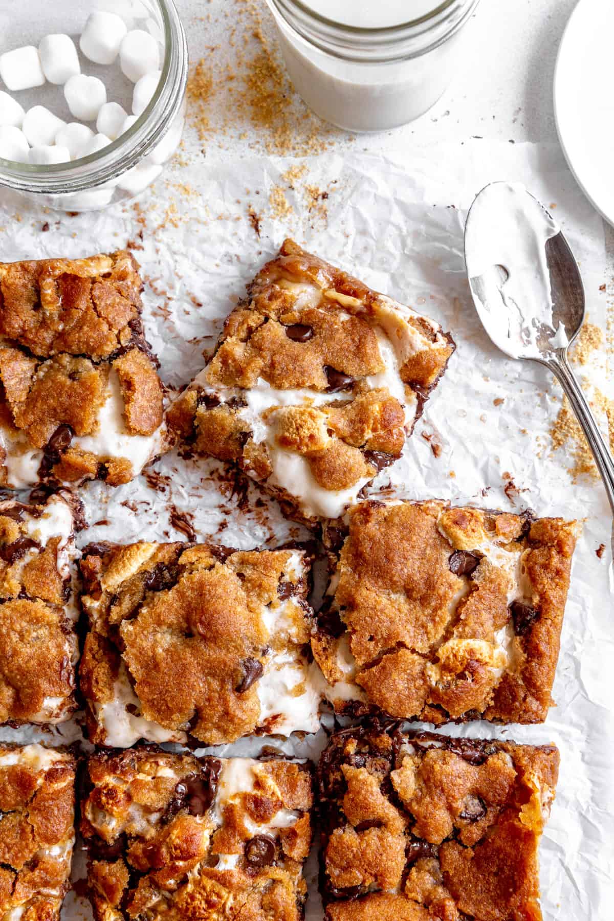 S'mores bars, white plates and a spoon covered in marshmallow fluff.