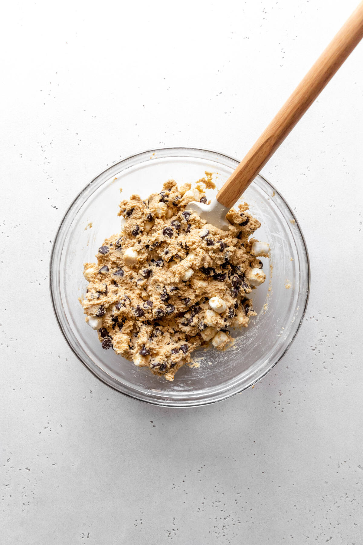 S'mores cookie dough in a glass bowl with a rubber spatula.
