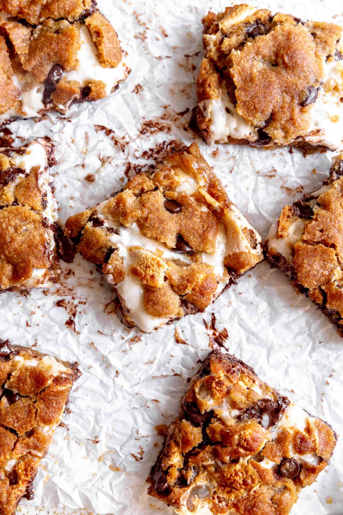 S'mores bars laid out on white parchment paper.