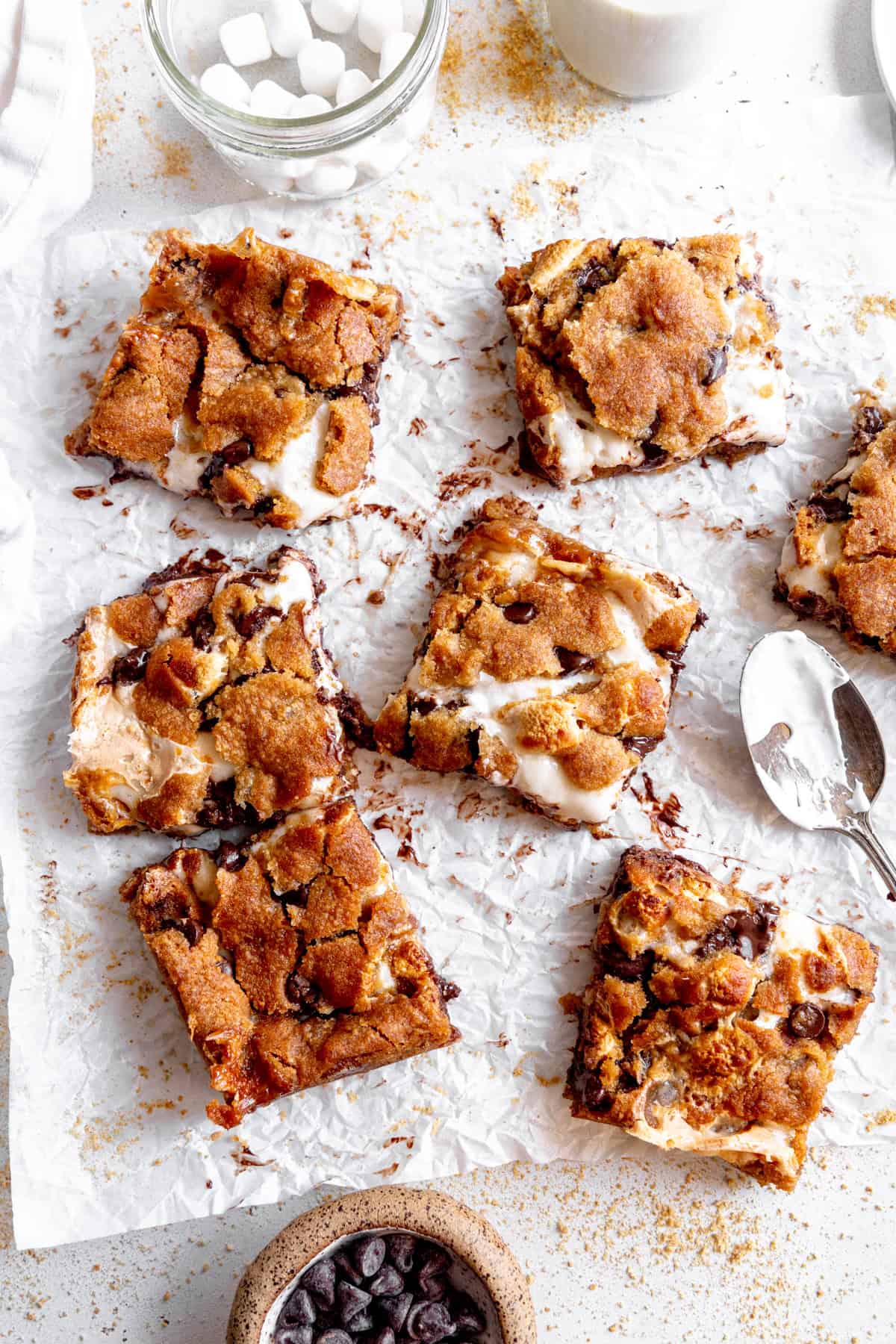 S'mores bars, a cup of chocolate chips and a cup of marshmallows.